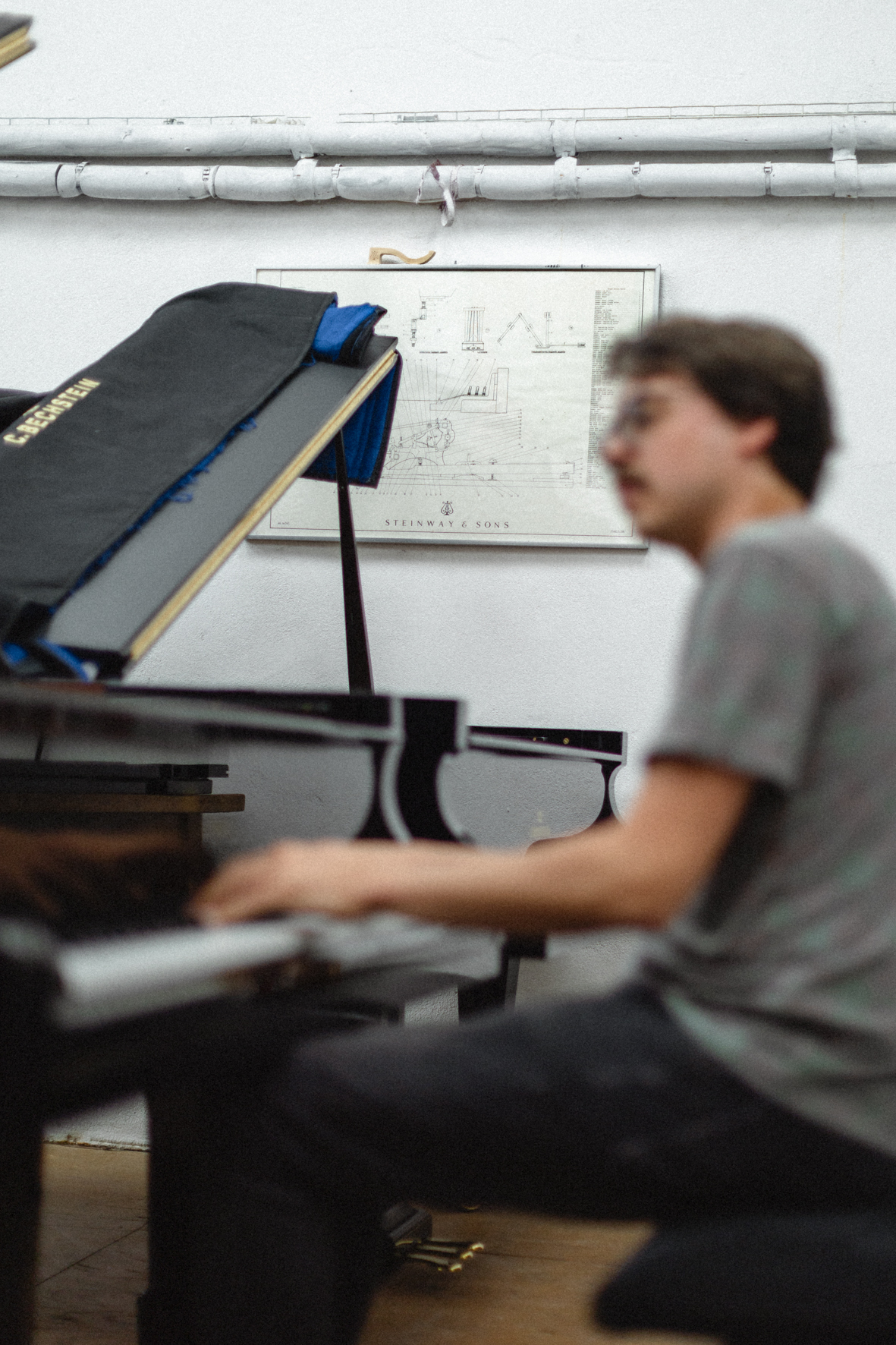 Le pianiste Lucas Debargue au choix de piano dans l'atelier d'accordeurs Pianomobil, photographié par Valentine Chauvin au Festival de Piano de la Roque d'Anthéron en juillet 2024